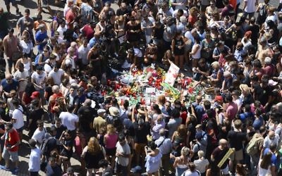 People gather to leave tributes on August 18, 2017 for the victims at the spot where a van ploughed into the crowd on August 17, 2017, killing 13 people and injuring over 100, on the Las Ramblas Boulevard in Barcelona, Spain. (AFP/Josep Lago)