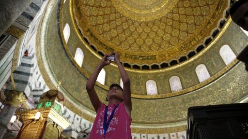 A Palestinian boy from the Gaza Strip takes a photo inside the Dome of the Rock mosque in the Al-Aqsa mosque compound in Jerusalem's old city on August 20, 2017 as he visits the city for the first time as part of an exchange program run by the UN agency for Palestinian refugees. (AFP PHOTO / AHMAD GHARABLI)