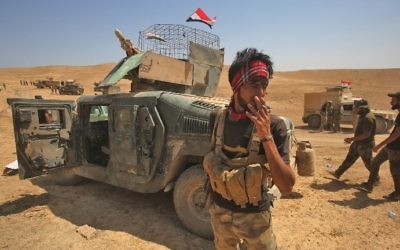 Shiite militia fighters from the Popular Mobilization Forces advance towards the city of Tal Afar on August 21, 2017. (AFP Photo/Ahmad al-Rubaye)