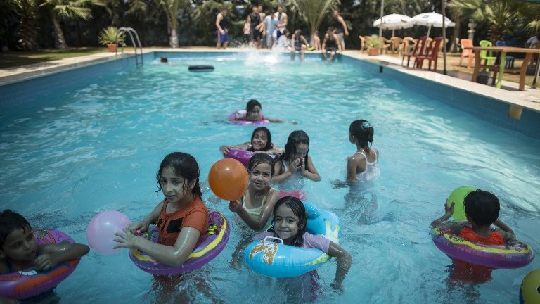Palestinians spend time at the pool in Gaza City on July 24, 2017. (AFP Photo/Mahmud Hams)