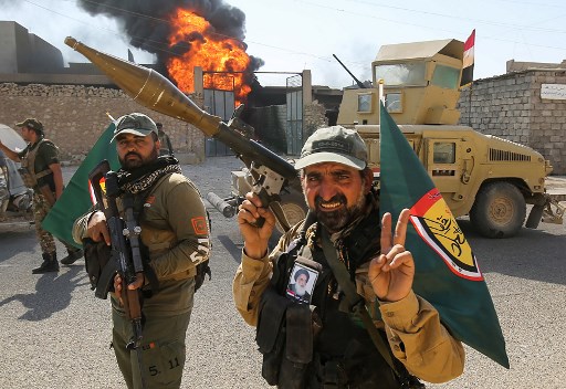 Fighters of Hashed Al-Shaabi (Popular Mobilization units) gather at the Tal Afar airport, west of Mosul, as Iraqi forces backed by local militia and a US-led coalition advanced in driving the Islamic State group from the city, on August 27, 2017. (AFP Photo/Ahmad al-Rubaye)