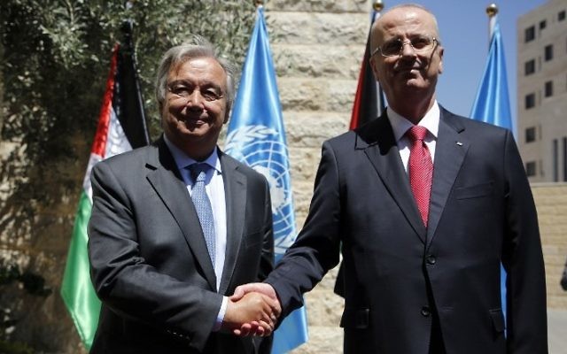 United Nations Secretary General Antonio Guterres (L) is greeted by Palestinian Authority Prime Minister Rami Hamdallah (R) in the West Bank city of Ramallah on August 29, 2017. (AFP Photo/Abbas Momani)