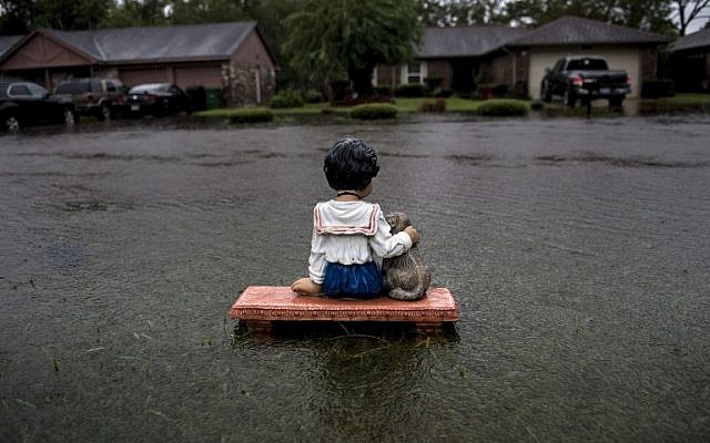 A lawn ornament is seen on a flooded street during the aftermath of Hurricane Harvey August 29, 2017 in Houston, Texas.Harvey has set what forecasters believe is a new rainfall record for the continental US, officials said Tuesday. Harvey, swirling for the past few days off Texas and Louisiana has dumped more than 49 inches (124.5 centimeters) of rain on the region. / AFP PHOTO / Brendan Smialowski