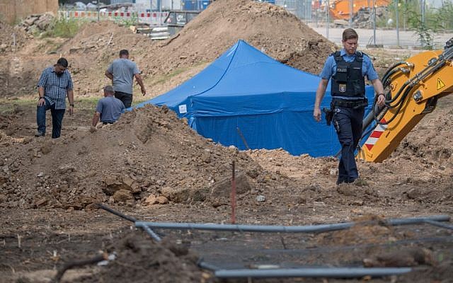 A policeman walks past a blue tent covering a British World War II bomb that was found during construction works on August 30, 2017 in Frankfurt am Main, western Germany. (AFP Photo/DPA/Boris Roessler/Germany OUT)