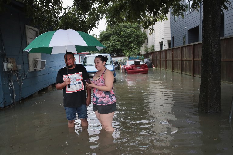 Vincente Navas (L) and Alma Barrientos stand outside their home in the Cottage Grove neighborhood which has been inundated with flooding from Hurricane Harvey on August 27, 2017 in Houston, Texas. (Scott Olson/Getty Images/AFP)