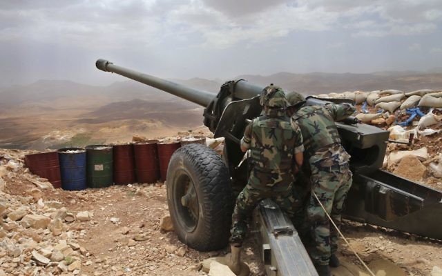 Lebanese army soldiers work on a 130mm howitzer cannon, pointed at areas controlled by Islamic State group militants near Arsal, in northeast Lebanon, June 19, 2016. (AP/Hussein Malla)