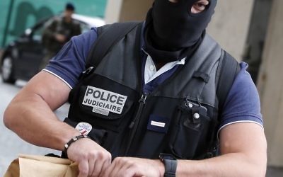 French police officer carries a bag from the scene where French soldiers were hit and injured by a vehicle in the western Paris suburb of Levallois-Perret near Paris, France, Wednesday, Aug. 9, 2017. (AP Photo/Kamil Zihnioglu)