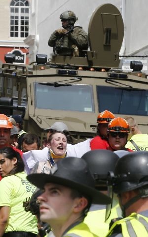 Rescue personnel help injured people after a car ran into a large group of protesters after a white nationalist rally in Charlottesville, Virginia, August 12, 2017.(AP Photo/Steve Helber)