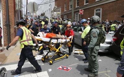 Rescue personnel help injured people after a car ran into a large group of protesters after a white nationalist rally in Charlottesville, Virginia, August 12, 2017.(AP Photo/Steve Helber)