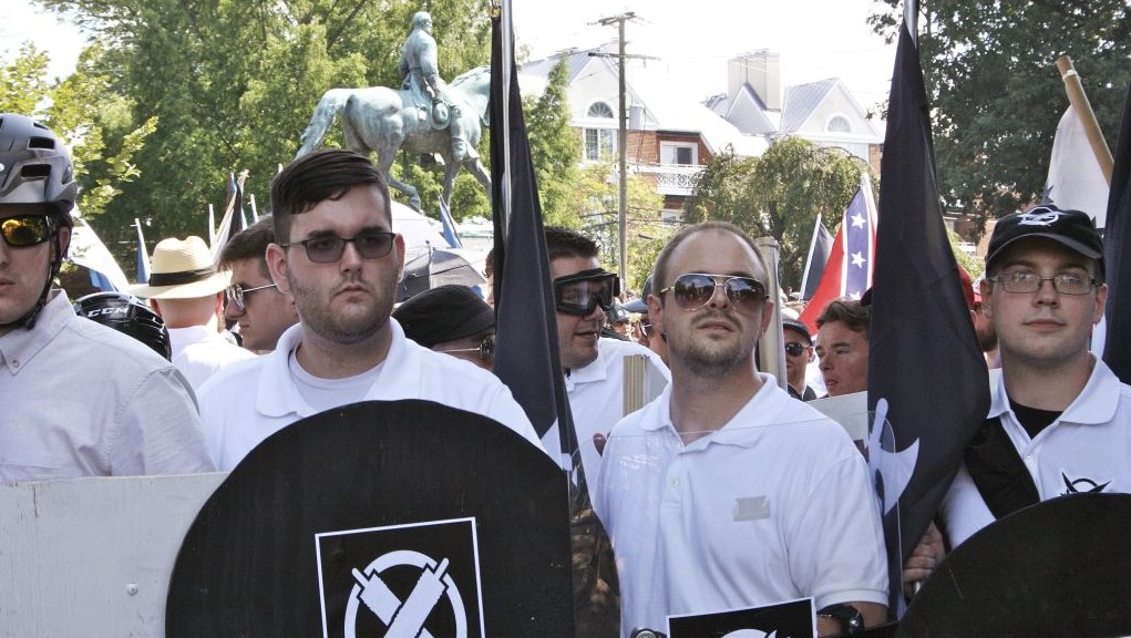 In this Saturday, Aug. 12, 2017 photo, James Alex Fields Jr., second from left, holds a black shield in Charlottesville, Va., where a white supremacist rally took place. Fields was later charged with second-degree murder and other counts after authorities say he plowed a car into a crowd of people protesting the white nationalist rally. (Alan Goffinski via AP)