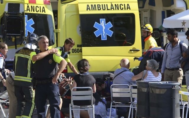 Injured people are treated in Barcelona, Spain, Thursday, Aug. 17, 2017 after a white van jumped the sidewalk in the historic Las Ramblas district, crashing into a summer crowd of residents and tourists. (AP Photo/Oriol Duran)