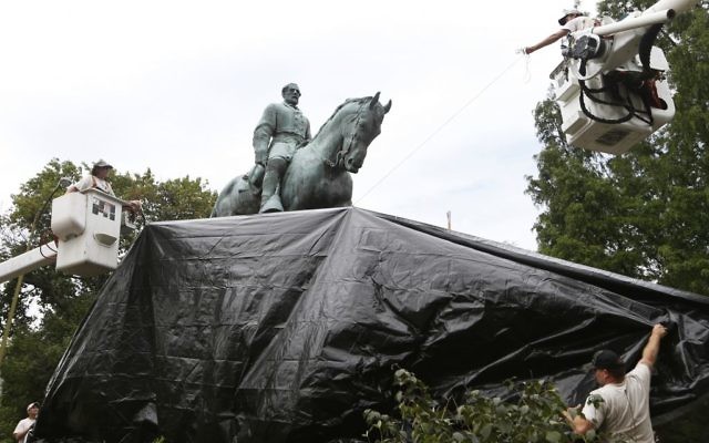 City workers drape a tarp over the statue of Confederate General Robert E. Lee in Emancipation park in Charlottesville, Virginia, August 23, 2017. (AP Photo/Steve Helber)