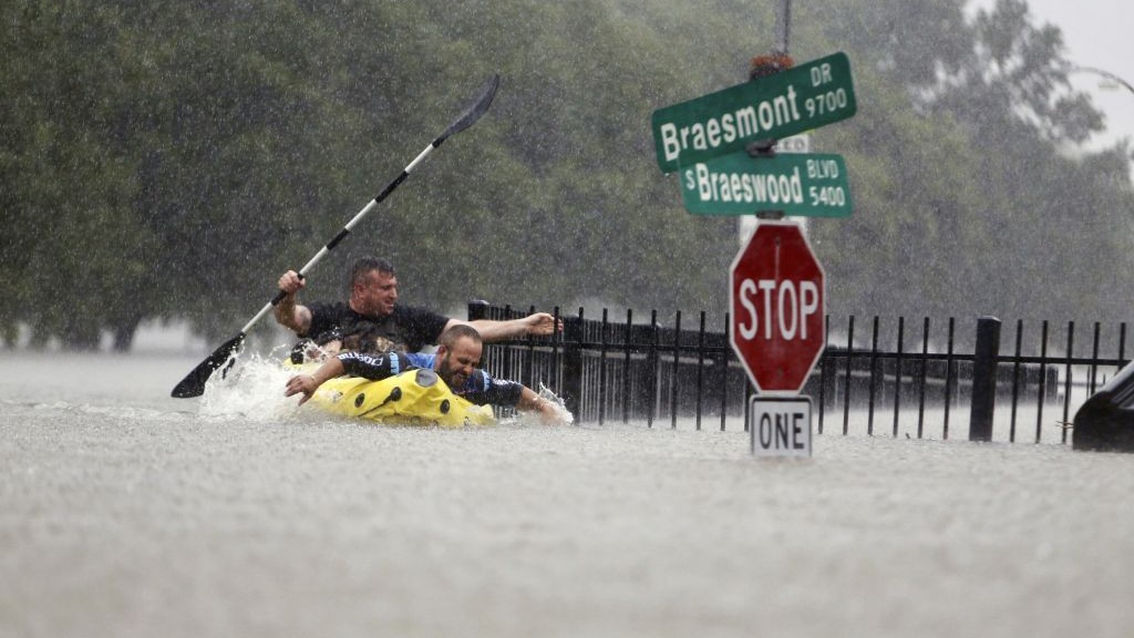 Two kayakers try to beat the current pushing them down an overflowing Brays Bayou from Tropical Storm Harvey in Houston, Texas, Sunday, Aug. 27, 2017. (Mark Mulligan/Houston Chronicle via AP)