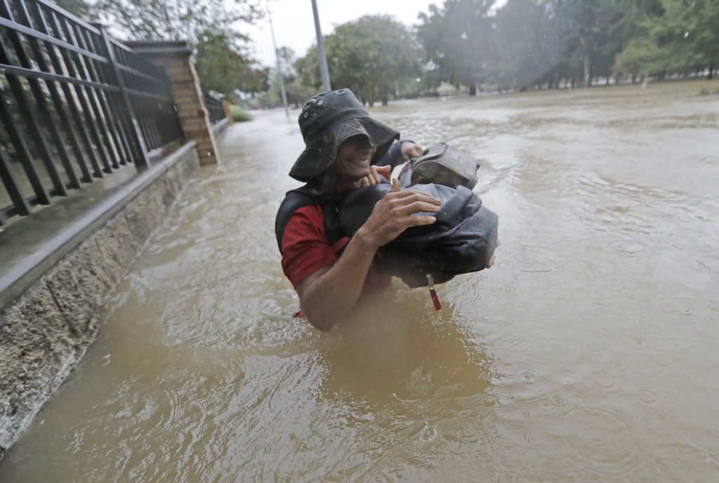 Residents wade through floodwaters from Tropical Storm Harvey Sunday, Aug. 27, 2017, in Houston, Texas. (AP Photo/David J. Phillip)