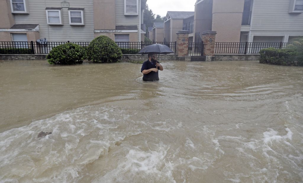 A man wades through floodwaters from Tropical Storm Harvey on Sunday, Aug. 27, 2017, in Houston, Texas. (AP Photo/David J. Phillip)
