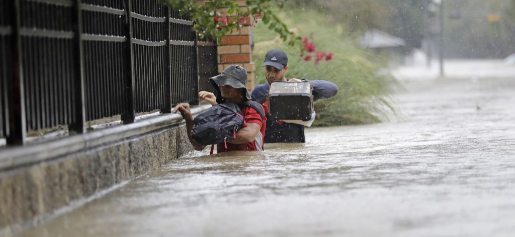 Residents wade through floodwaters from Tropical Storm Harvey Sunday, Aug. 27, 2017, in Houston, Texas. (AP Photo/David J. Phillip)