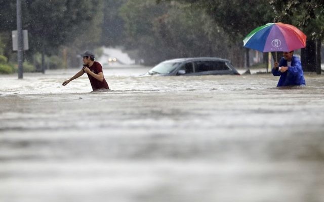 Moses Juarez, left, and Anselmo Padilla wade through floodwaters from Tropical Storm Harvey, August 27, 2017, in Houston, Texas. (AP Photo/David J. Phillip)