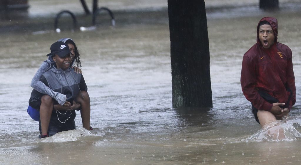 Residents wade through floodwaters from Tropical Storm Harvey Sunday, Aug. 27, 2017, in Houston, Texas. (AP Photo/David J. Phillip)