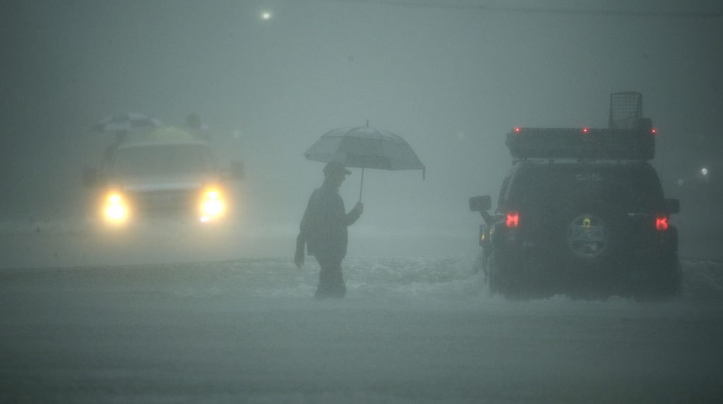 A man walks through floodwaters from Tropical Storm Harvey as he evacuates his home on Sunday, Aug. 27, 2017, in Houston, Texas. (AP Photo/Charlie Riedel)