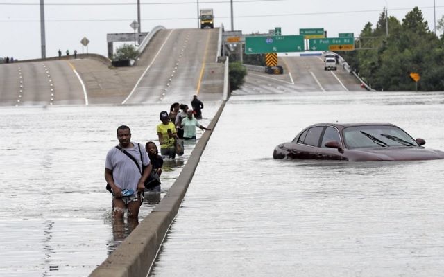 Evacuees wade down a flooded section of Interstate 610 as floodwaters from Tropical Storm Harvey rise, August 27, 2017, in Houston. (AP Photo/David J. Phillip)