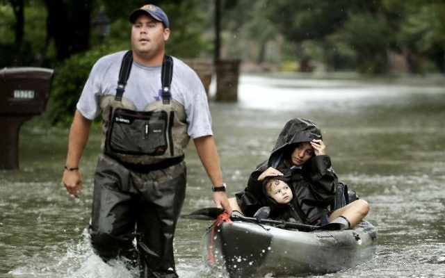 People evacuate a neighborhood inundated by floodwaters from Tropical Storm Harvey on Monday, Aug. 28, 2017, in Houston, Texas. (AP/Charlie Riedel)