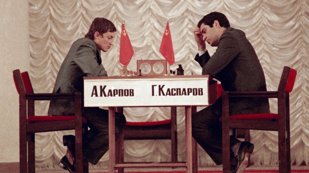 Former World Chess Champion, Garry Kasparov, right, talks to the media as  FIDE presidential candidate and former World Chess Champion, Anatoly Karpov,  left, and President of English Chess Federation, CJ de Mooi listen on  during their World Chess