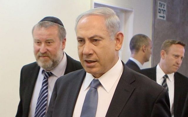 Prime Minister Benjamin Netanyahu (C) arrives at the weekly cabinet meeting at the Prime Minister's Office flanked by then-cabinet secretary Avichai Mendelblit (L) and then-chief of staff Ari Harow (behind), March 9, 2014. (Danny Meron/Pool/Flash90)