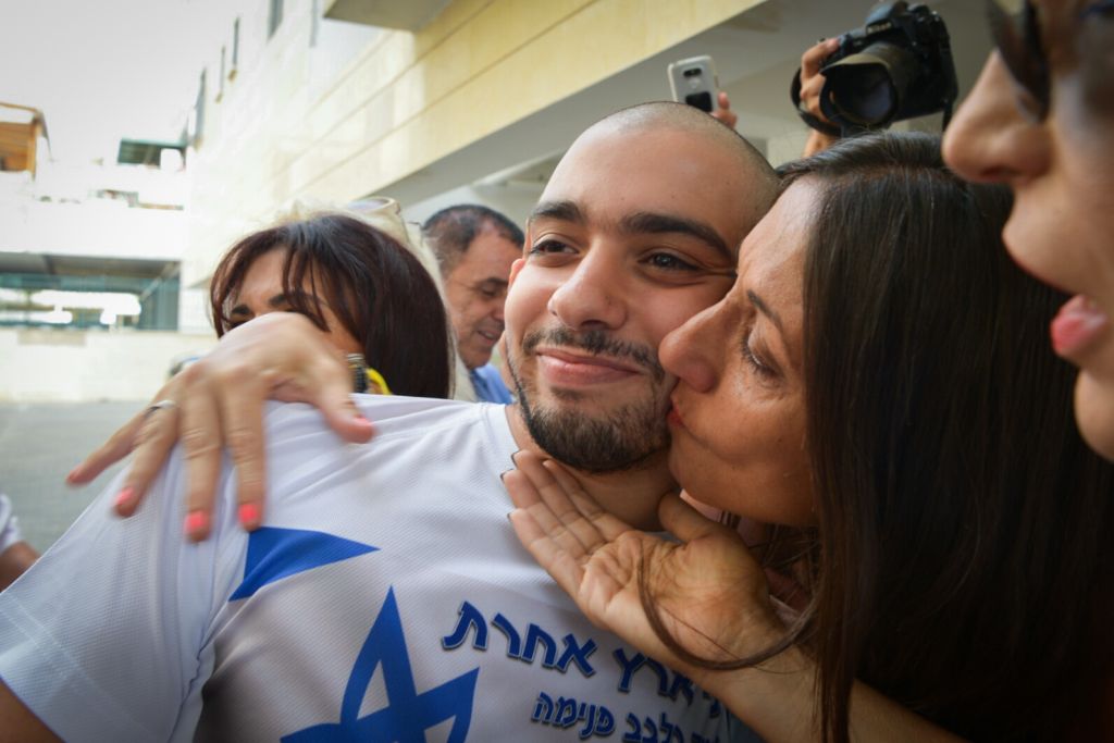 Elor Azaria, a former IDF soldier who shot dead a disarmed and injured Palestinian attacker in the West Bank city of Hebron, seen with his mother as he leaves his home for prison on August 9, 2017 (Avi Dishi/Flash90)