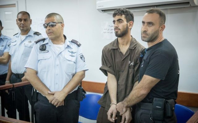 Omar Al-Abed, in handcuffs, is brought to a courtroom for his trial at the Israel's Ofer military court near the West Bank city of Ramallah on August 17, 2017. (Yonatan Sindel/Flash90)
