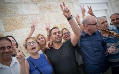 Menny Naftali (C), the former housekeeper of Prime Minister's Residence, and Israeli activist Eldad Yaniv (2R) outside the courtroom of the High Court in Jerusalem, August 24, 2017. (Yonatan Sindel/Flash90)