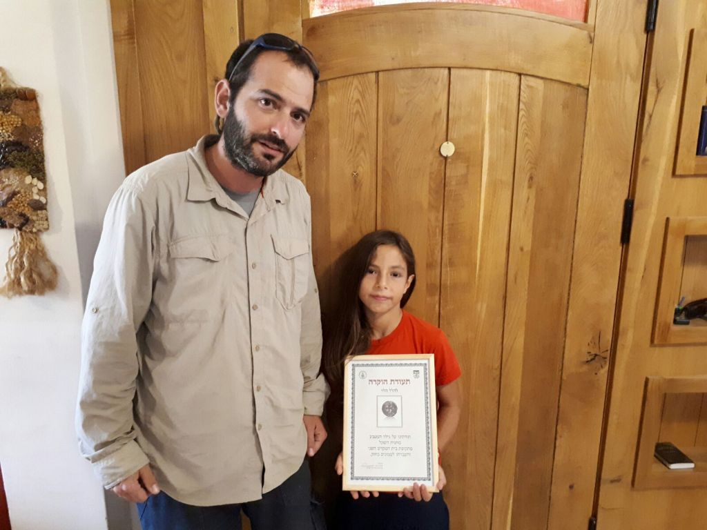 8-year-old Hallel Halevy with the Civil Administration archaeologist who collected the '2,000-year-old half-shekel' coin from her home in Halamish, August 23, 2017. (courtesy)