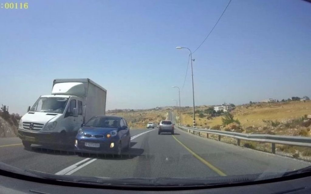 The blue vehicle attempts to pass the white truck by merging into the oncoming traffic lane, nearly colliding with the approaching vehicle on Route 60 in the West Bank. (Courtesy: Avraham Binyamin)