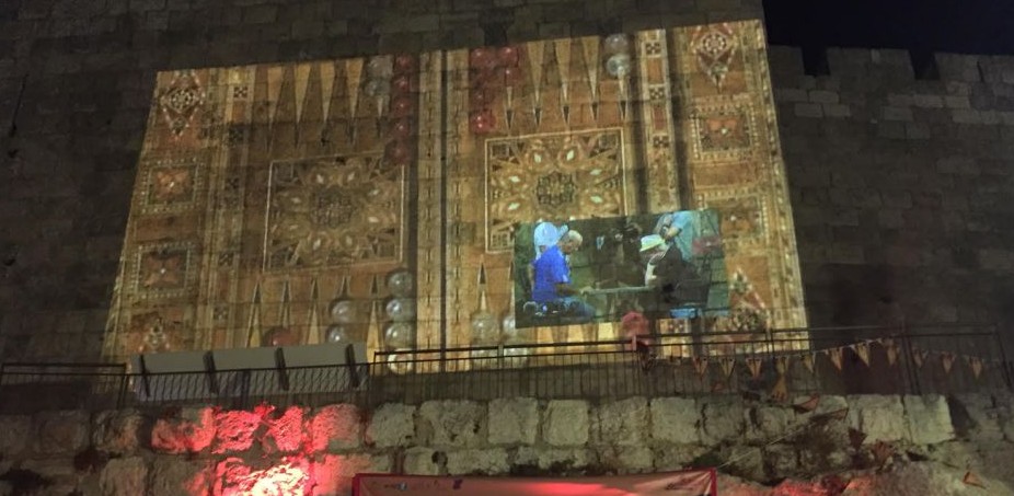 The final game of the first Jerusalem Backgammon Championship is beamed onto the Old City walls (Times of Israel staff)