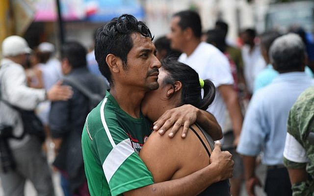 A couple embraces on September 8, 2017 in Juchitan de Zaragoza, state of Oaxaca, where buildings collapsed after an 8.2 earthquake that hit Mexico's Pacific coast overnight. (AFP PHOTO / Pedro PARDO)