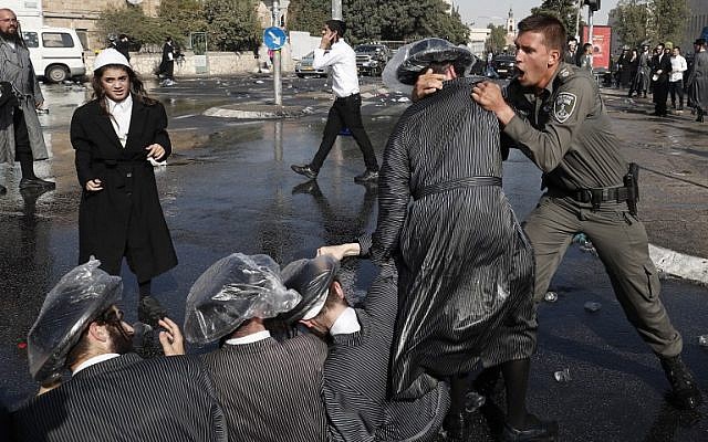 Israeli security forces remove ultra-Orthodox Jewish demonstrators belonging to the hardline Eda Haredit group from a road in an ultra-Orthodox neighborhood of Jerusalem on September 17, 2017. (AFP Photo/Ahmad Gharabli)