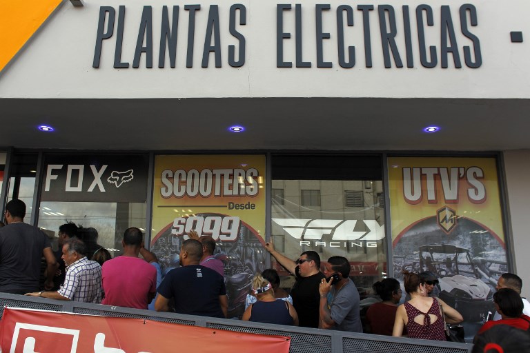 A line of customers waits for the arrival of generators at a power sports store as Hurricane Maria approaches in San Juan, Puerto Rico on September 18, 2017. (AFP PHOTO / Ricardo ARDUENGO)