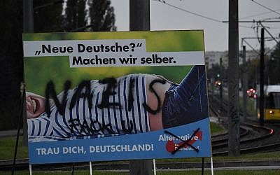 A vandalized Alternative for Germany paty campaign poster is seen in Berlin on September 21, 2017. (AFP Photo/John Macdougall)