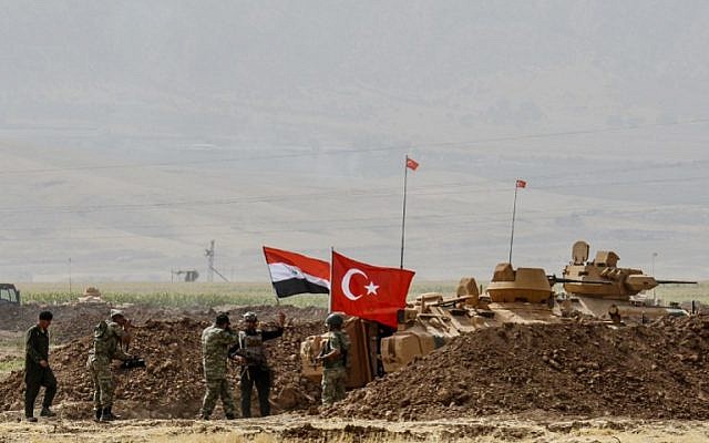 Soldiers stand next to tanks bearing Turkish and Iraqi flags during a joint military exercise near the Turkish-Iraqi border at Silopi district in Sirnak on September 26, 2017. (AFP Photo/Ilyas Akengin)