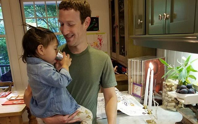 Mark Zuckerberg with his daughter Maxima in front of the Shabbat candles, September 15, 2017. (Facebook)