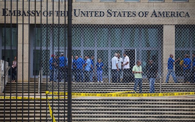 Staff stand within the United States Embassy facility in Havana, Cuba, Friday, Sept. 29, 2017. The United States issued an ominous warning to Americans on Friday to stay away from Cuba and ordered home more than half the U.S. diplomatic corps, acknowledging neither the Cubans nor America’s FBI can figure out who or what is responsible for months of mysterious health ailments. (AP Photo/Desmond Boylan)