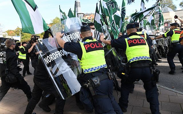 Police officers clash with members of the Nordic Resistance Movement during a demonstration in central Goteborg, Sweden, Saturday Sept. 30, 2017. (Fredrik Sandberg/TT via AP)