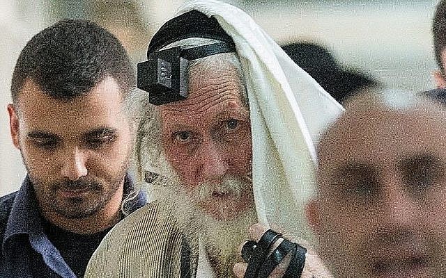Rabbi Eliezer Berland shrouds himself with his talit (prayer shawl) at the Magistrates Court in Jerusalem, as he is put on trial for sexual assault charges, November 17, 2016. (Yonatan Sindel/ Flash90)