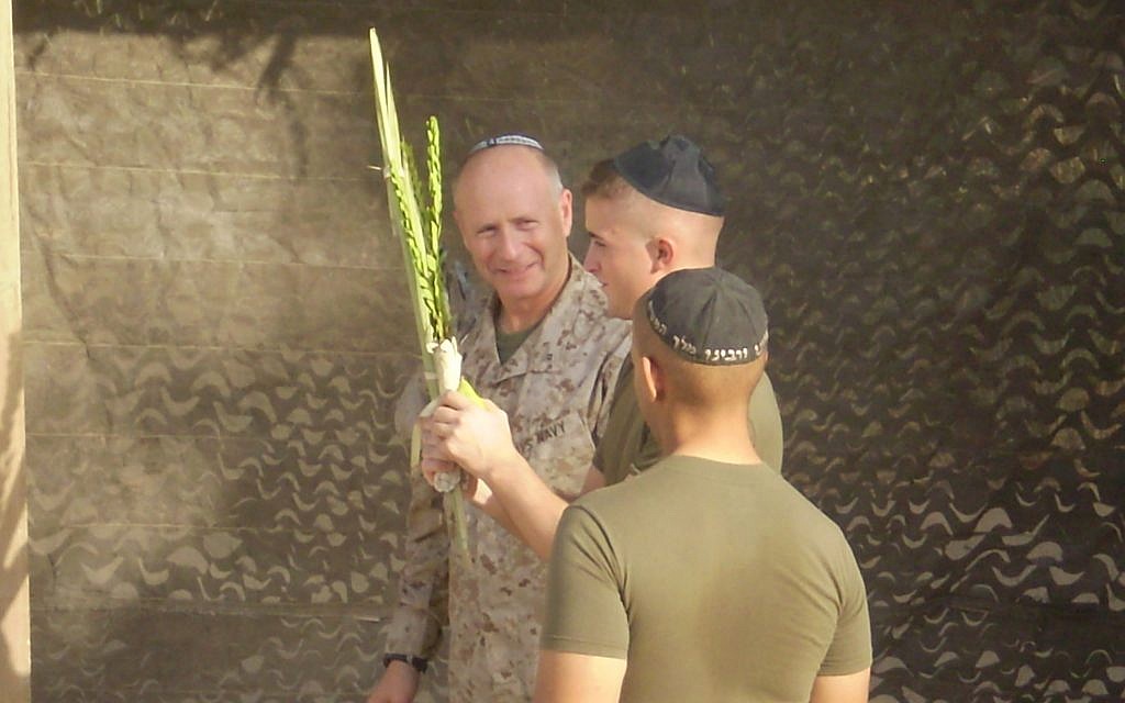Capt. Jon Cutler shakes the lulav and etrog with Jewish soldiers on the Sukkot holiday. (Courtesy)