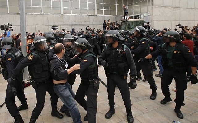 A man clashes with Spanish Guardia Civil guards outside a polling station in Sant Julia de Ramis, where the Catalan president was supposed to vote, on October 1, 2017, the day of a referendum on independence for Catalonia banned by Madrid. (AFP PHOTO / Raymond ROIG)