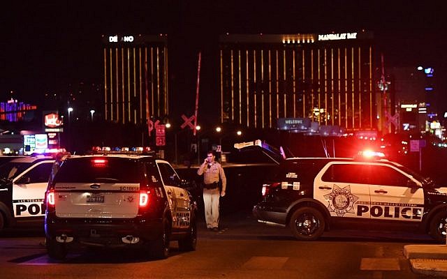 Police form a perimeter around the road leading to the Mandalay Hotel (background) after a gunman killed 58 people and wounded more than 500 others, when he opened fire on a country music concert in Las Vegas, Nevada, October 2, 2017. (AFP/Mark RALSTON)