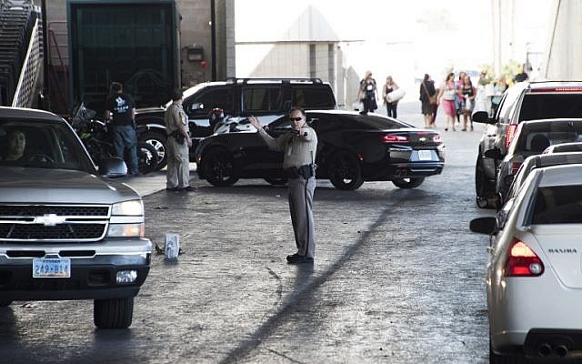 A sheriff's deputy directs cars arriving at the family assistance center at the Las Vegas Convention Center in order to learn more information about their loved ones following a mass shooting, on October 2, 2017. (AFP Photo/Robyn Beck)
