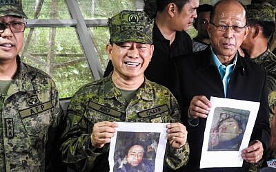 Philippines military chief General Eduardo Ano (C) holds a picture of Islamic terrorist leader Isnilon Hapilon as Defense Secretary Delfin Lorenzana (R) holds a picture of Omarkhayam Maute during a press conference at a military camp in Marawi, on the southern island of Mindanao, on October 16, 2017.
(AFP Photo/Ferdinandh Cabrera)