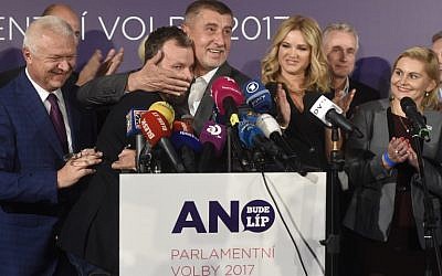 Czech billionaire Andrej Babis (C,R), chairman of the ANO movement (YES) kisses Marek Prchal, PR manager of ANO for social media at ANO headquarter after Czech elections on October 21, 2017 in Prague. (Michal Cizek/AFP)