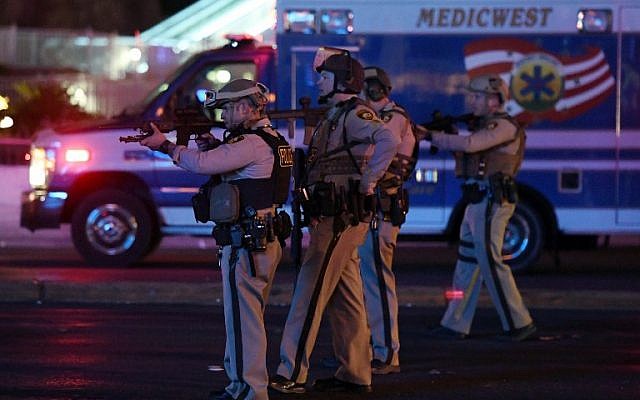 Police officers point their weapons at a car driving down closed Tropicana Ave. near Las Vegas Boulevard after a reported mass shooting at a country music festival nearby on October 2, 2017 in Las Vegas, Nevada. (Ethan Miller/Getty Images/AFP)