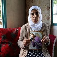 Manal al-Sayed holds up a picture of her son Hisham, who is believed to be held captive in Gaza by the Hamas terrorist group, in 2016. (Yoav Lemmer/AFP)